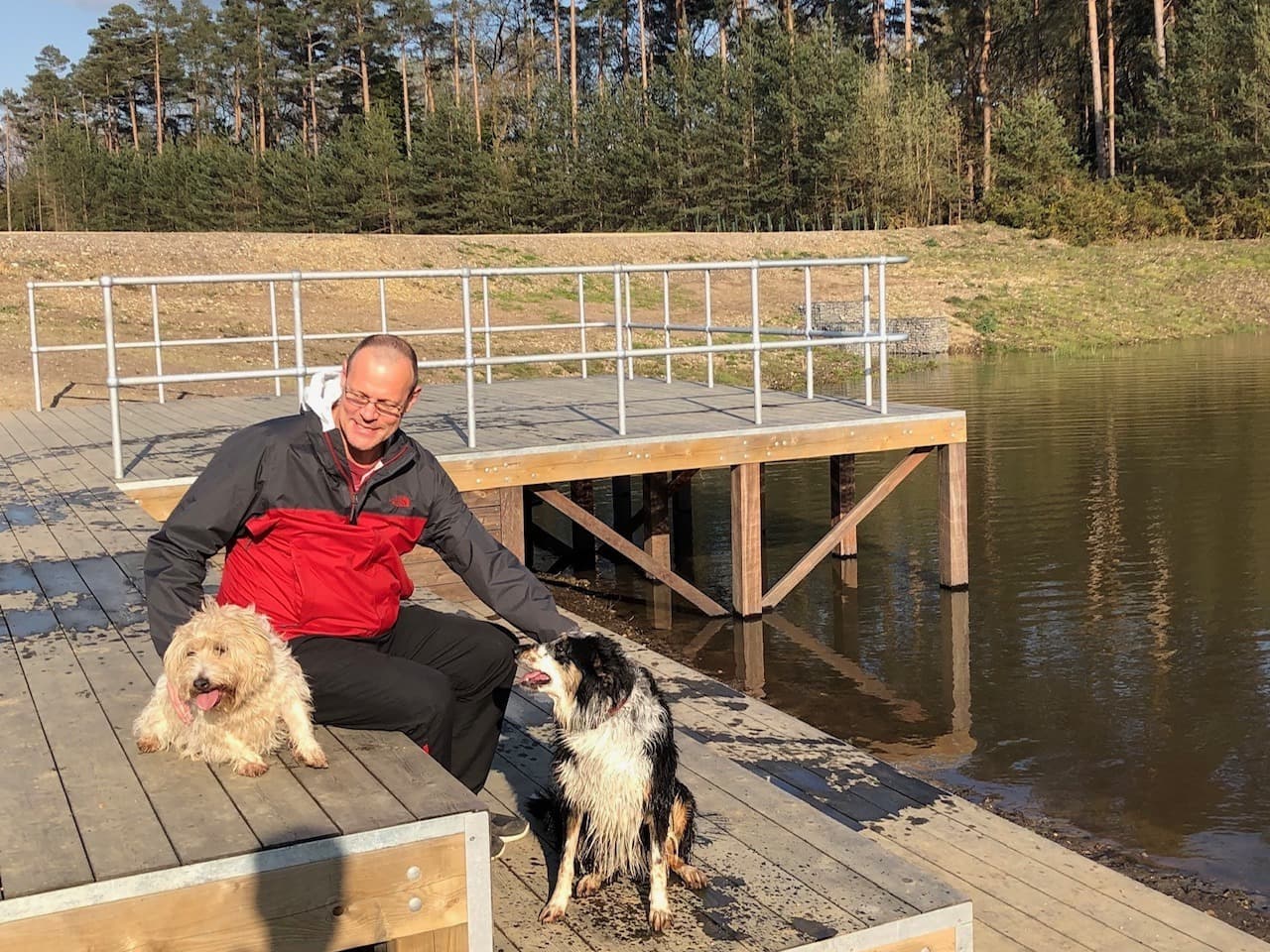 Michael Morrow on a lakeside dock with his dogs